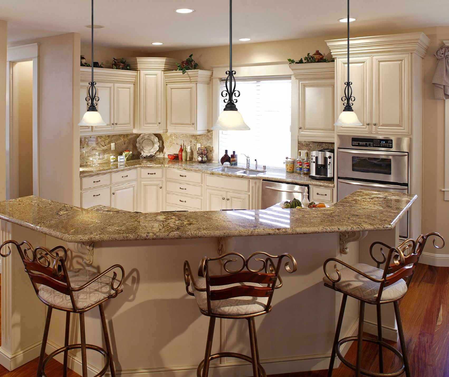 Mini pendant chandeliers cast an inviting glow in this traditional kitchen.