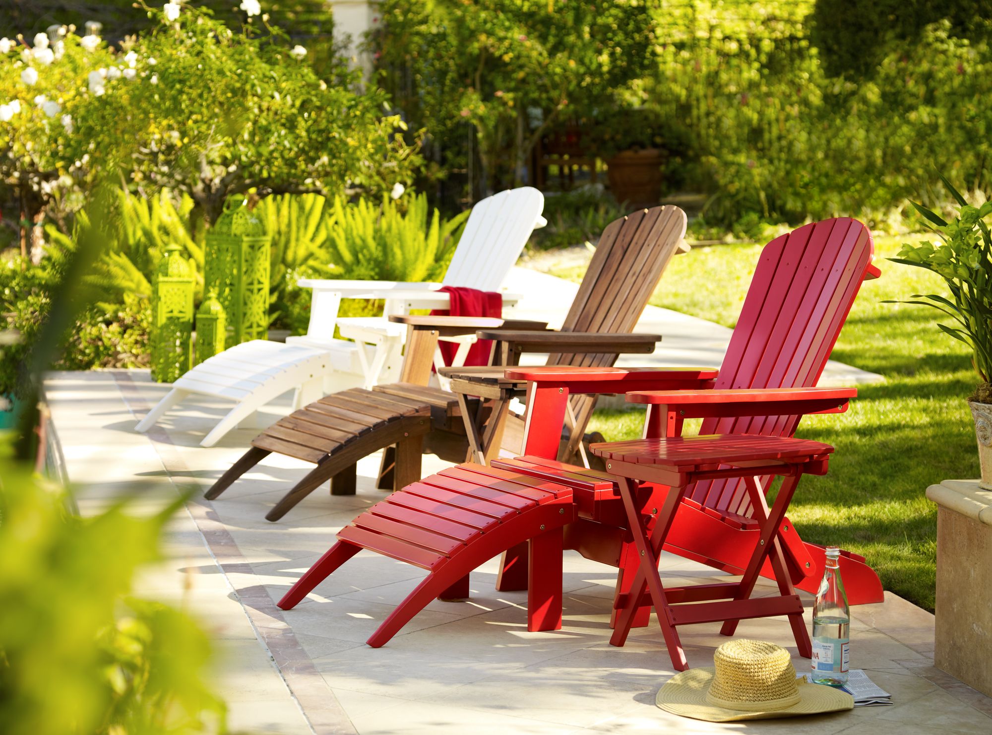 Classic slant wood Adirondack chairs brighten a poolside setting.