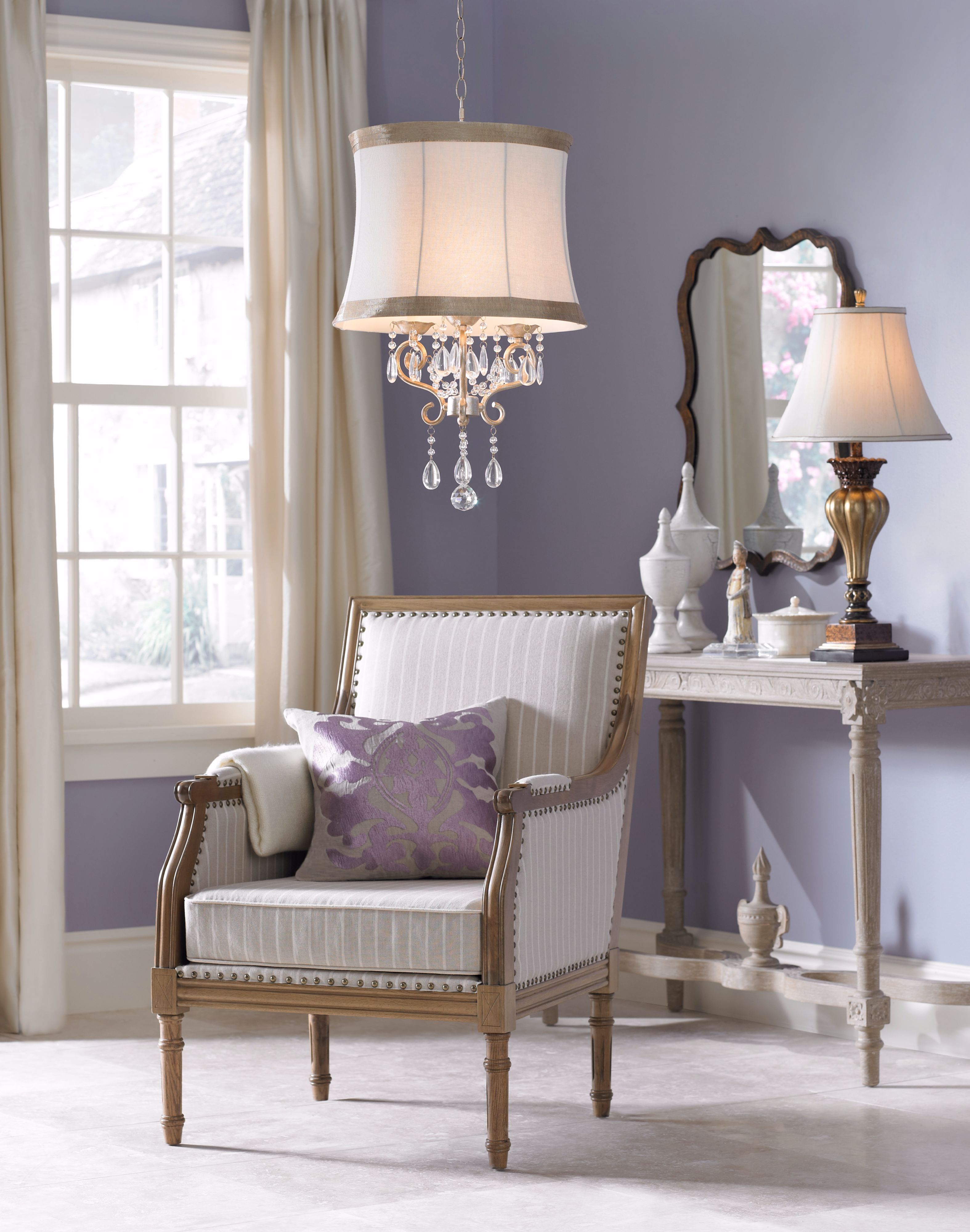 A shade chandelier brings sparkle and elegance to this bedroom seating area.