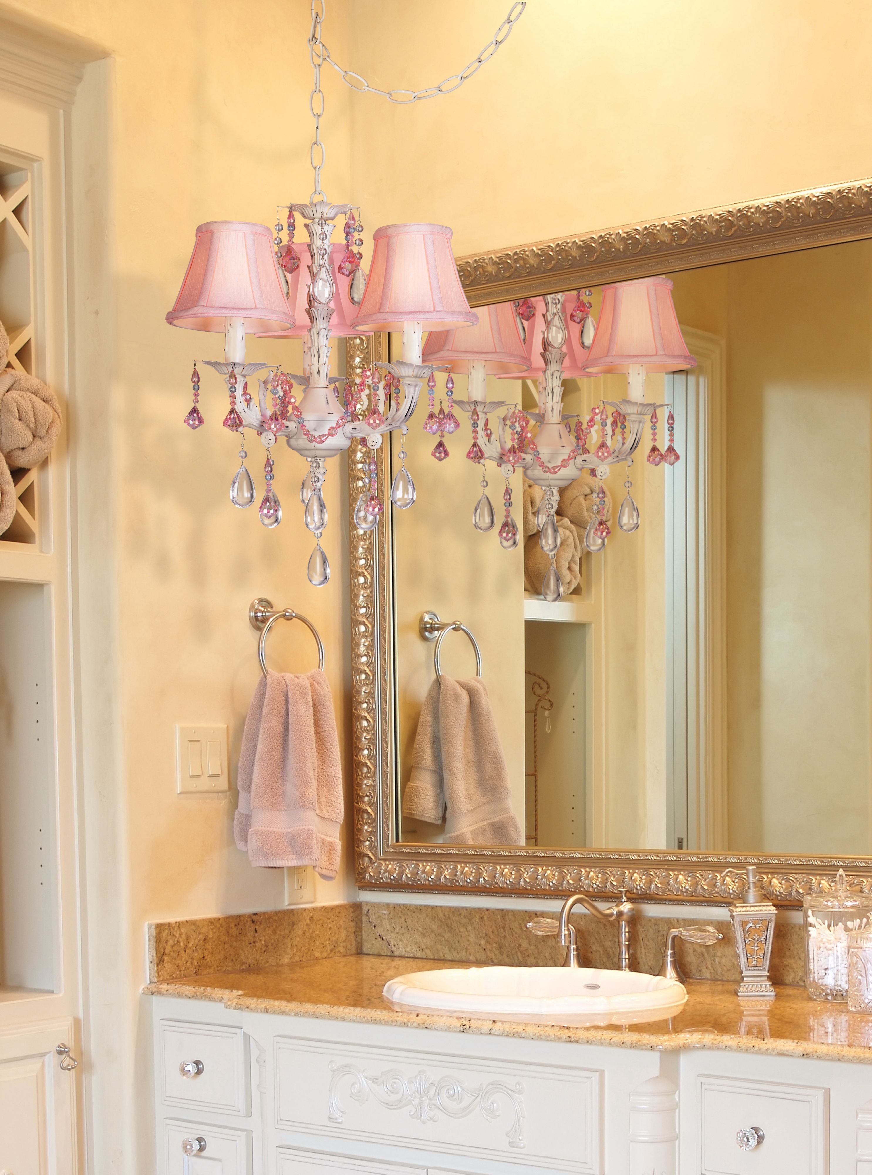 A delicate pink chandelier adds feminine charm to this bathroom picture.