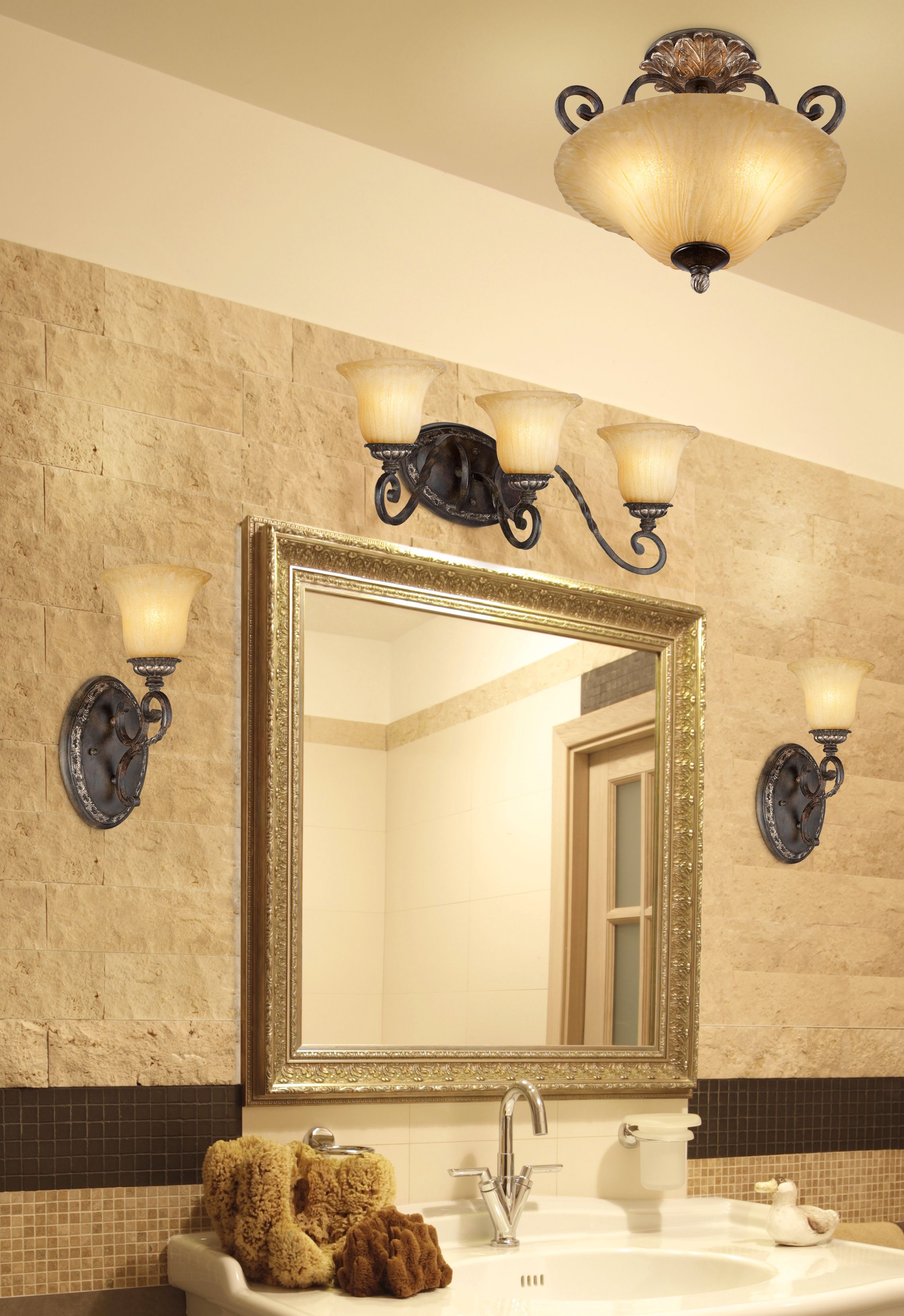 Bronze and gold light fixtures highlight this luxurious bathroom design.