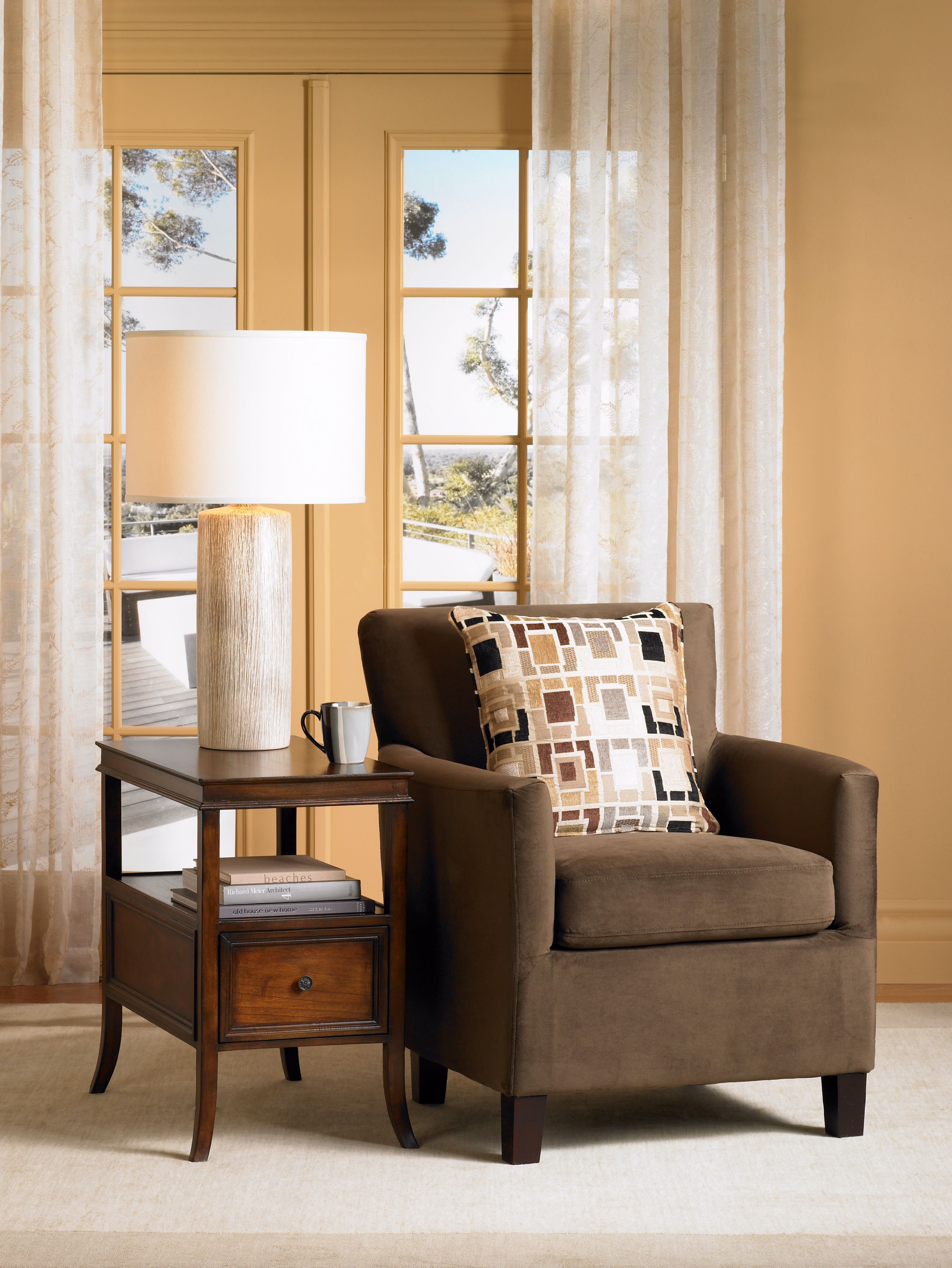 The similar hues of the table lamp and throw pillow balance the design.