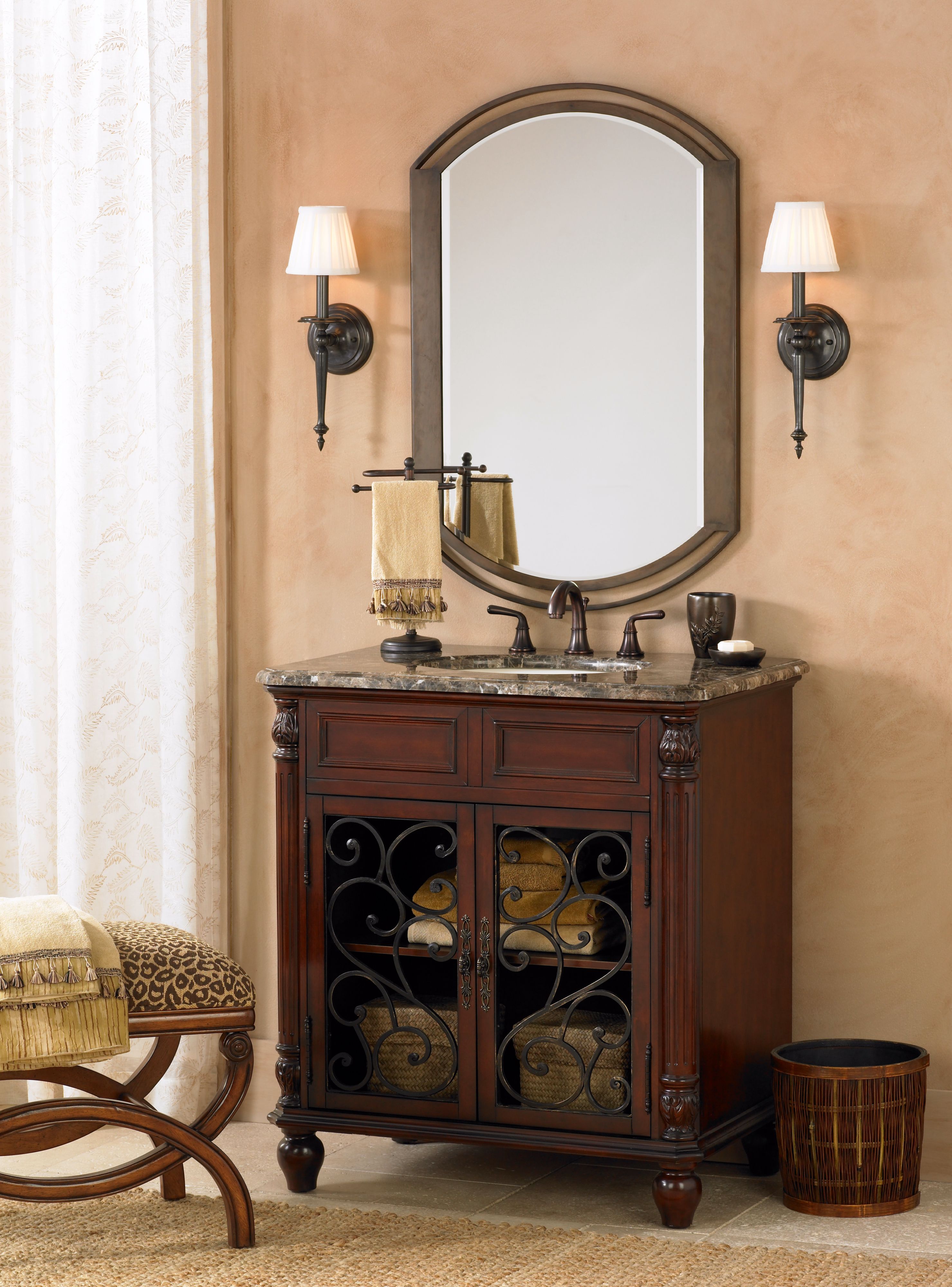 The cherry bathroom vanity with iron scrollwork creates a sophisticated space.