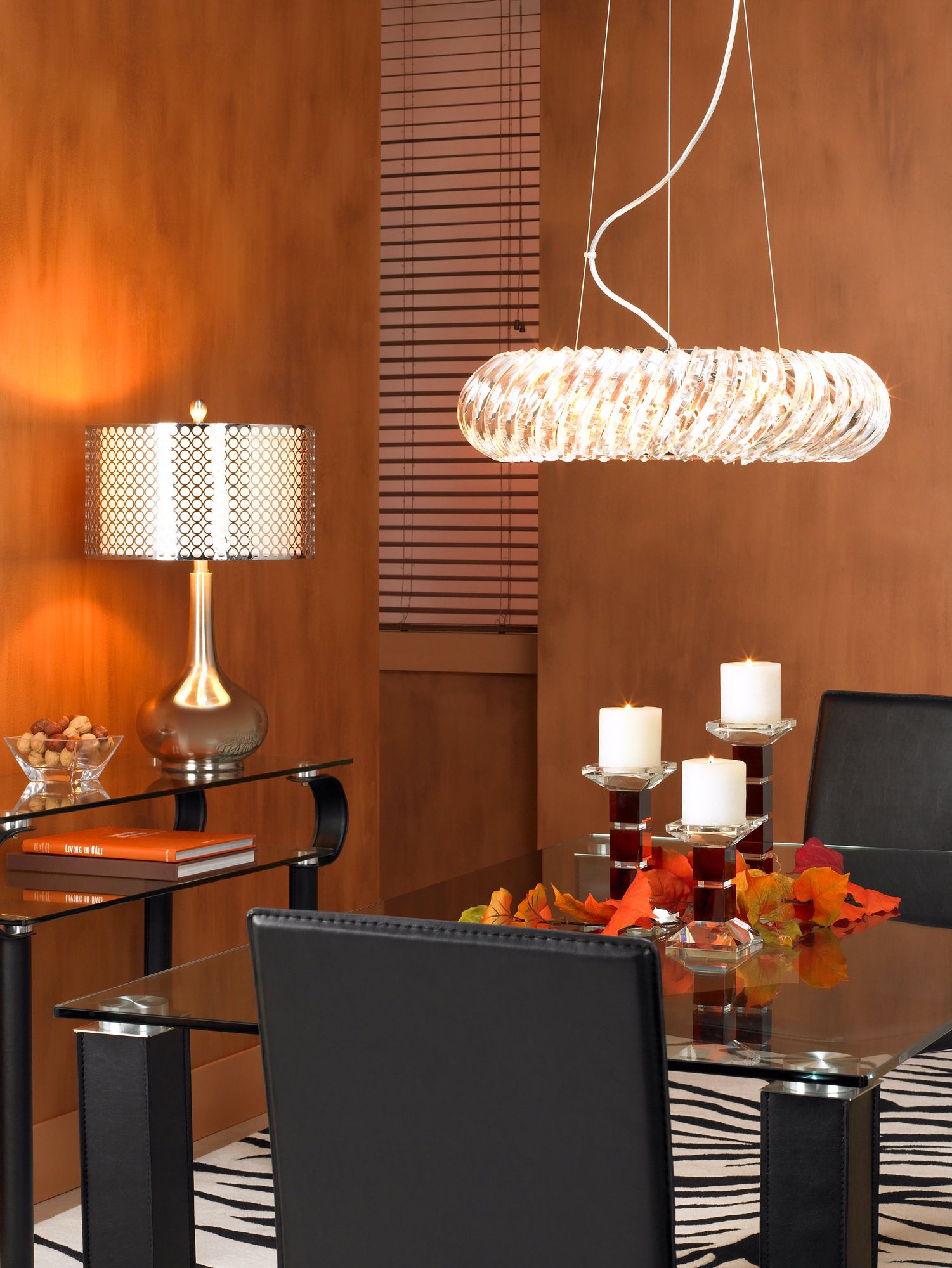 The dining room's glass and chrome finishes are balanced with amber hues.