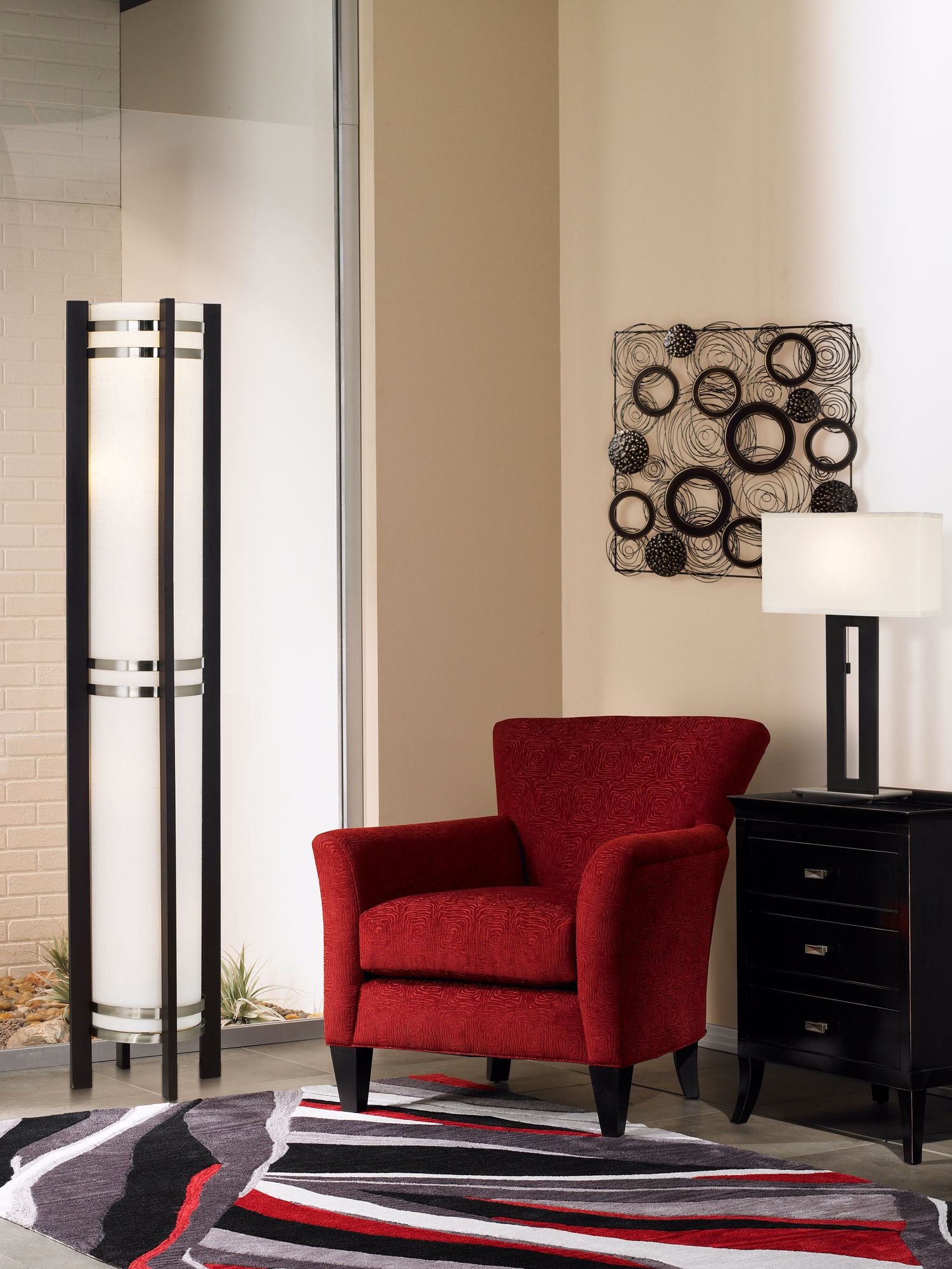 The wall art and black area rug defines the pattern in the living room picture.