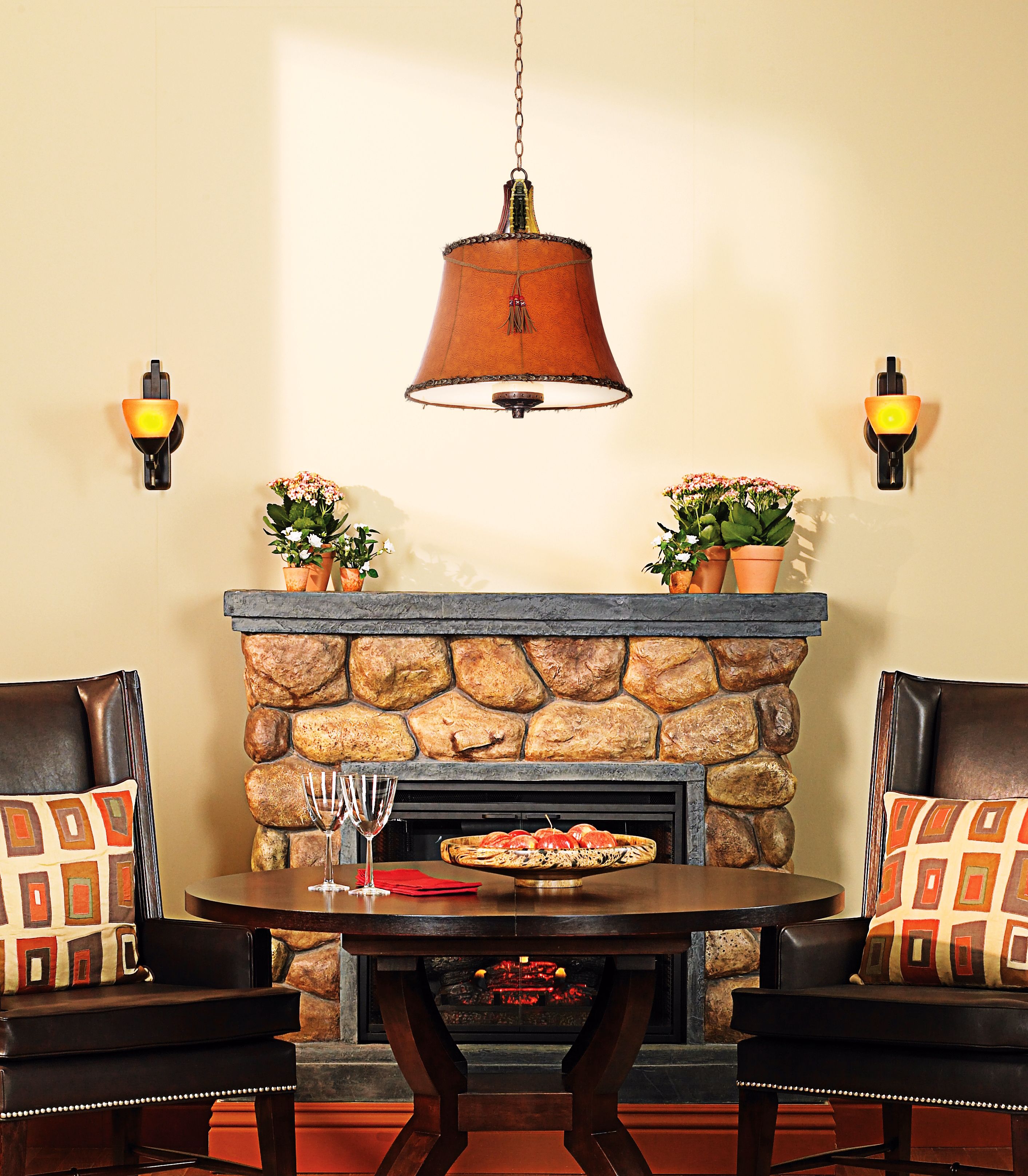 A rustic dining room with a hanging pendant chandelier and leather chairs.