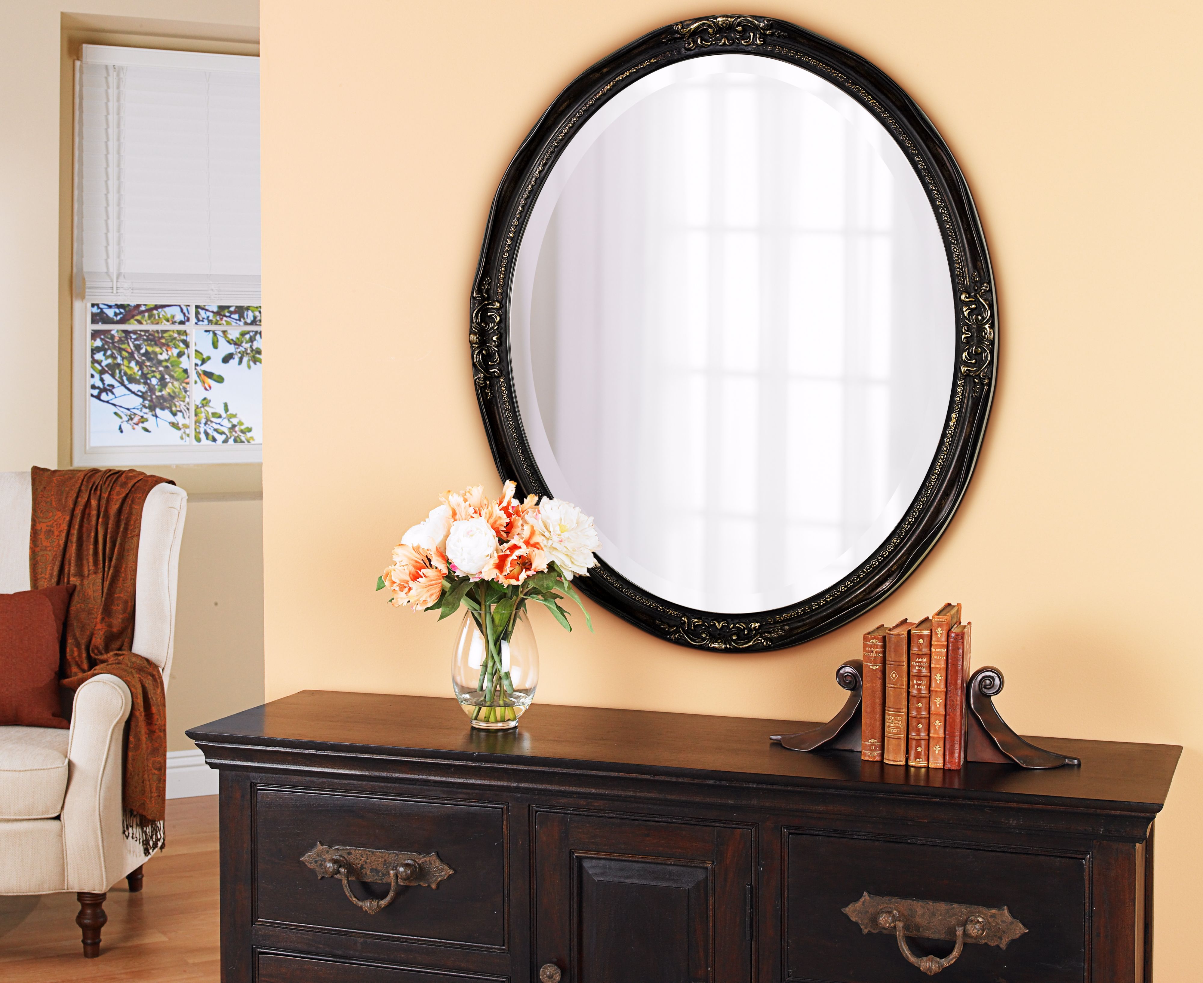 A large oval mirror brightens a traditional entryway.