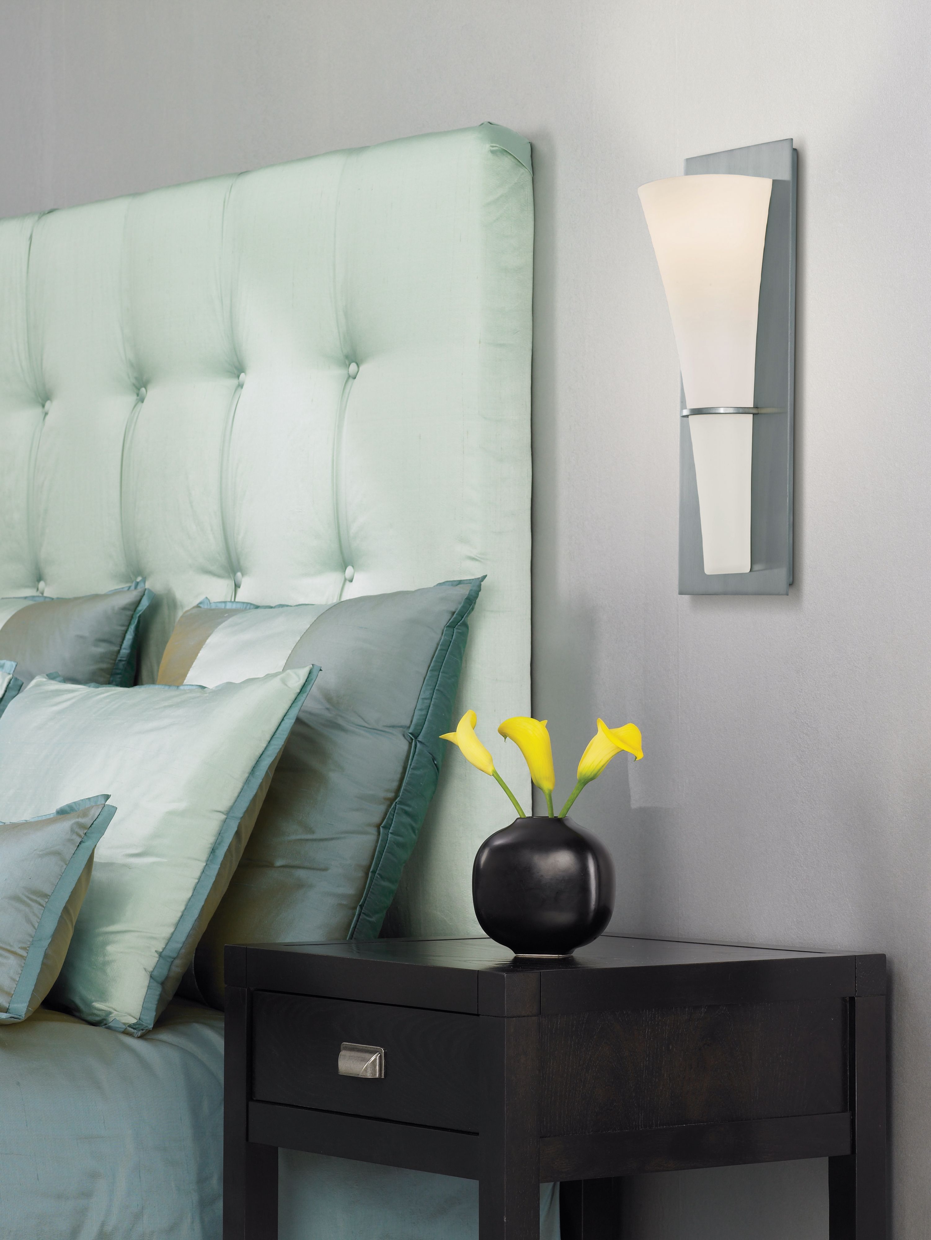 Wall mounted sconces are a great alternative to table lamps in a bedroom design.