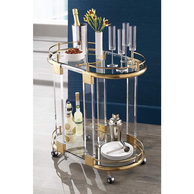 Image 1 Adaline 29 1/2" Wide Clear Acrylic and Gold Oval Bar Cart in scene