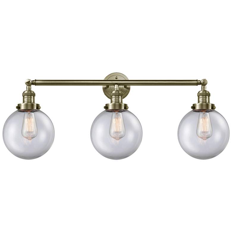 Image 1 Beacon 3 Light 32" LED Bath Light - Antique Brass - Clear Shade